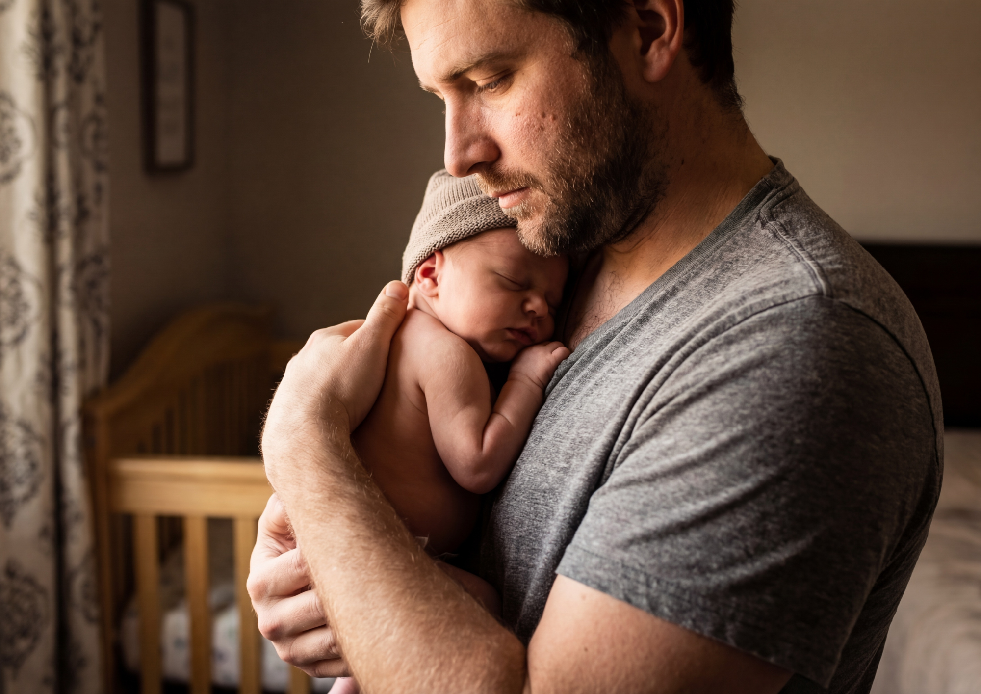A father holding his sleeping newborn against his chest